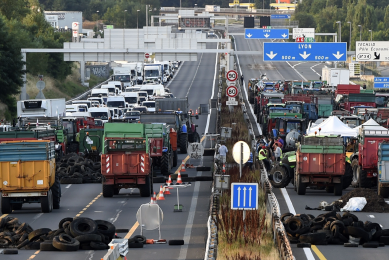 French farmers block the A6 motorway with tractors, farm trailers and tyres at the northern entrance to Lyon, on July 23, 2015, one of the key arteries to the southern regions for holiday-makers. AFP