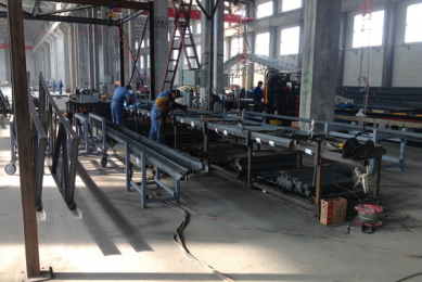 People at work in the new manufacturing plant in Jiaozhou. In the background, the framework of a new poultry house is visible.