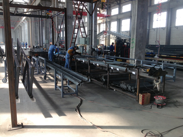 People at work in the new manufacturing plant in Jiaozhou. In the background, the framework of a new poultry house is visible.