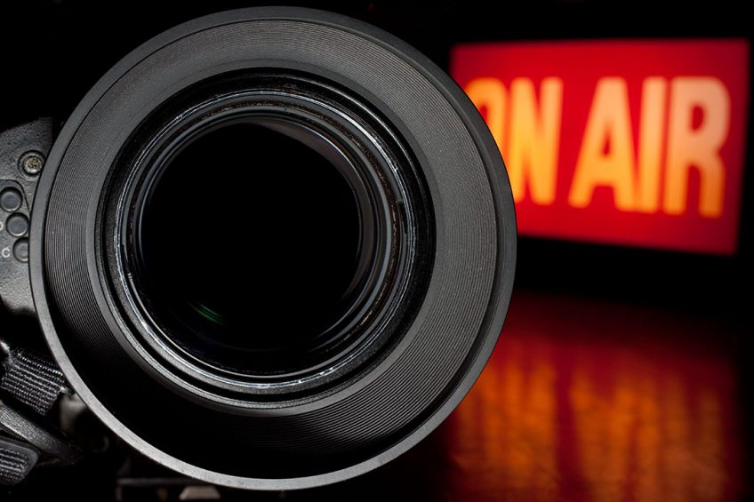 Television Film Camera with focus on the rim of the lens. On Air Broadcast sign in the background.; Shutterstock ID 77786614; Purchase Order: Pig Progress