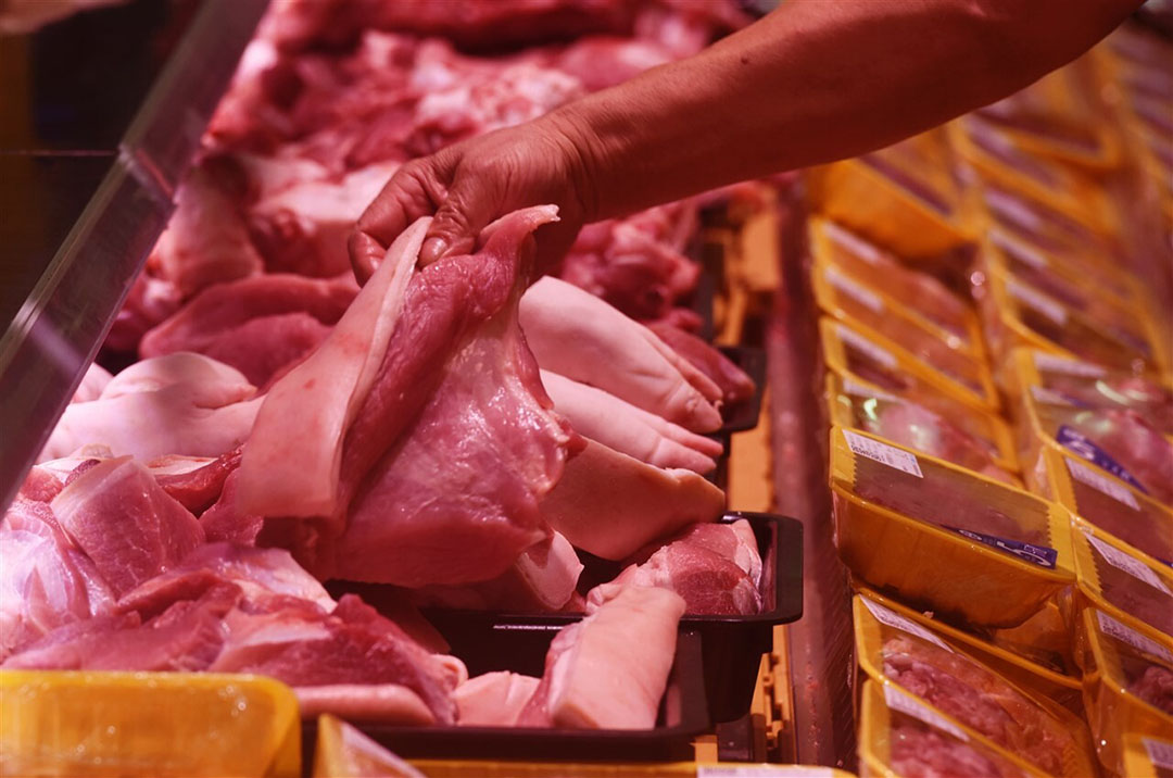 A customer selects pork at a supermarket in Hangzhou, Zhejiang province, China. Rabobank expects a rebound in Chinese pork demand. Photo: SIPA USA