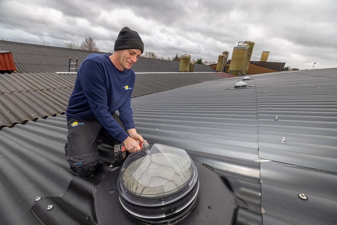 Dennis de Vries is installing one of the light shafts onto the roof.