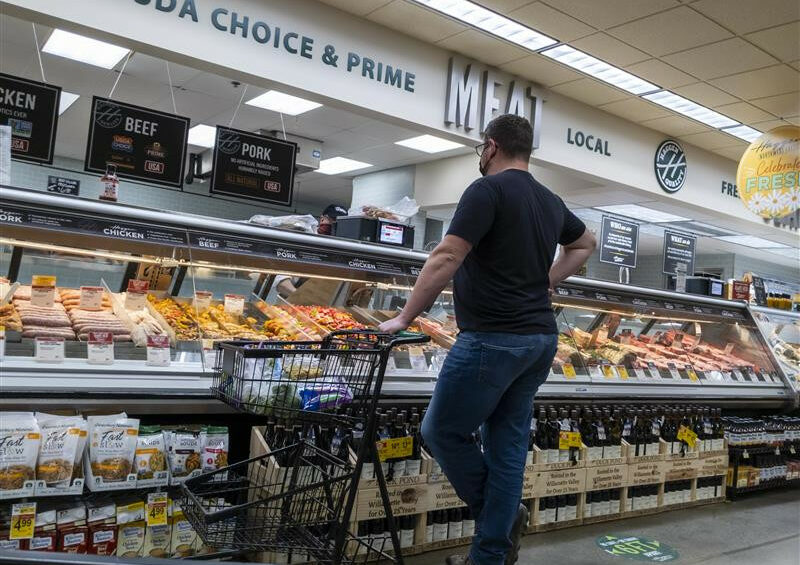 Will I go for pork today? A man contemplating his choices at a supermarket in Washington state, USA. Photo: Dreamstime